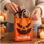 Hände legen ein Geschenk in eine Halloween Geschenktüte