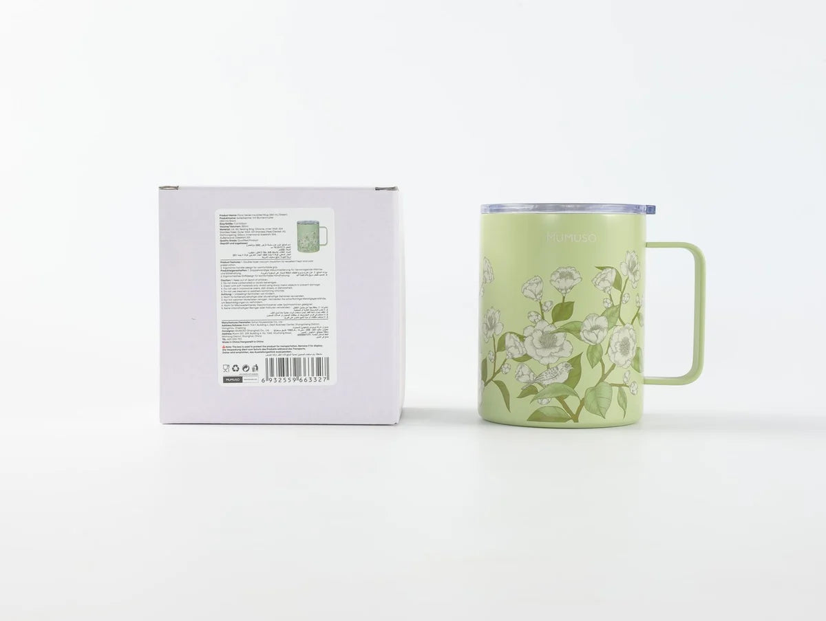 Grüner floraler Isolierbecher mit Verpackung auf weißem Hintergrund