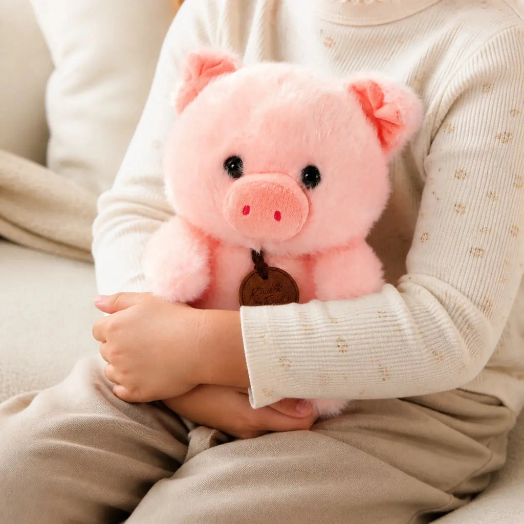 Kind hält das rosa Schwein Plüschtier